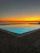 A serene sunset over the private pool with warm golden light reflecting on calm water.
