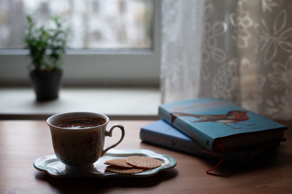 a cup of coffee and a book on a table