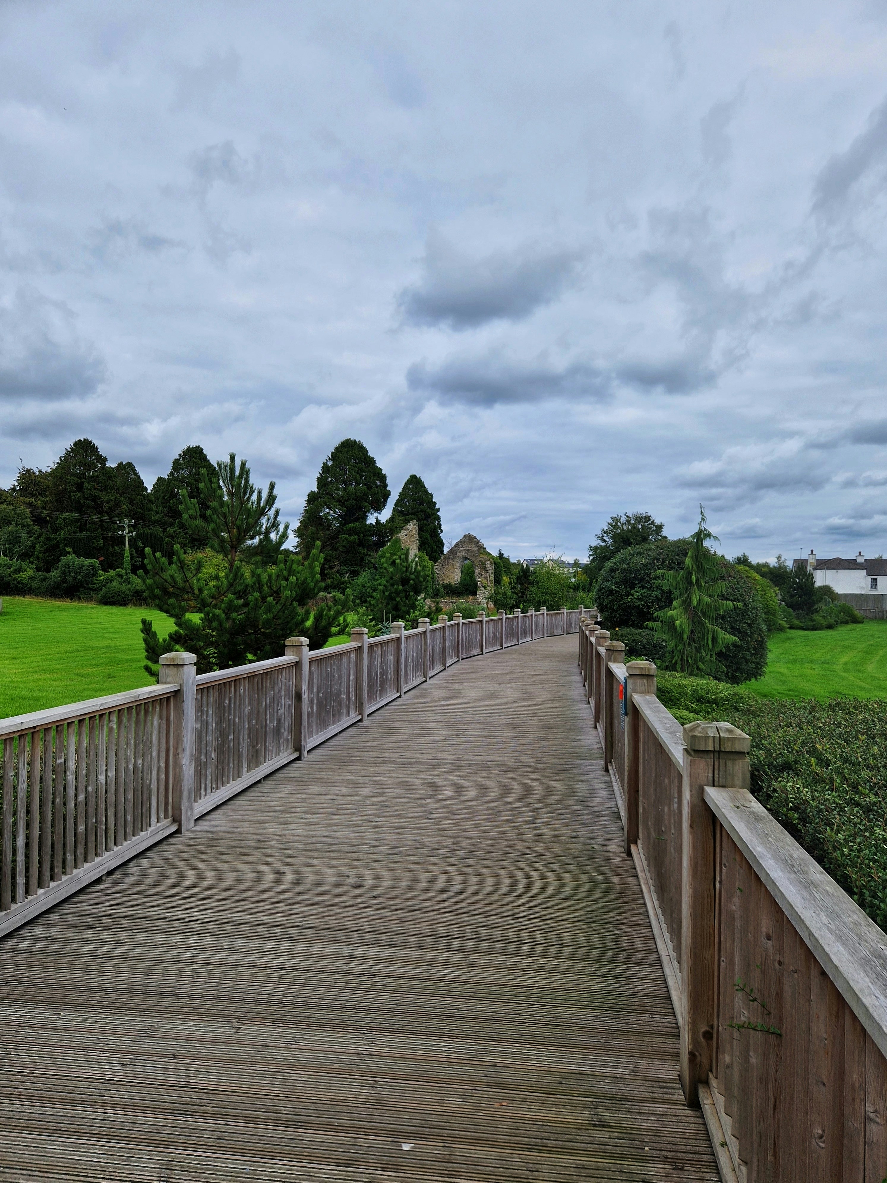 a wooden bridge over a grassy field