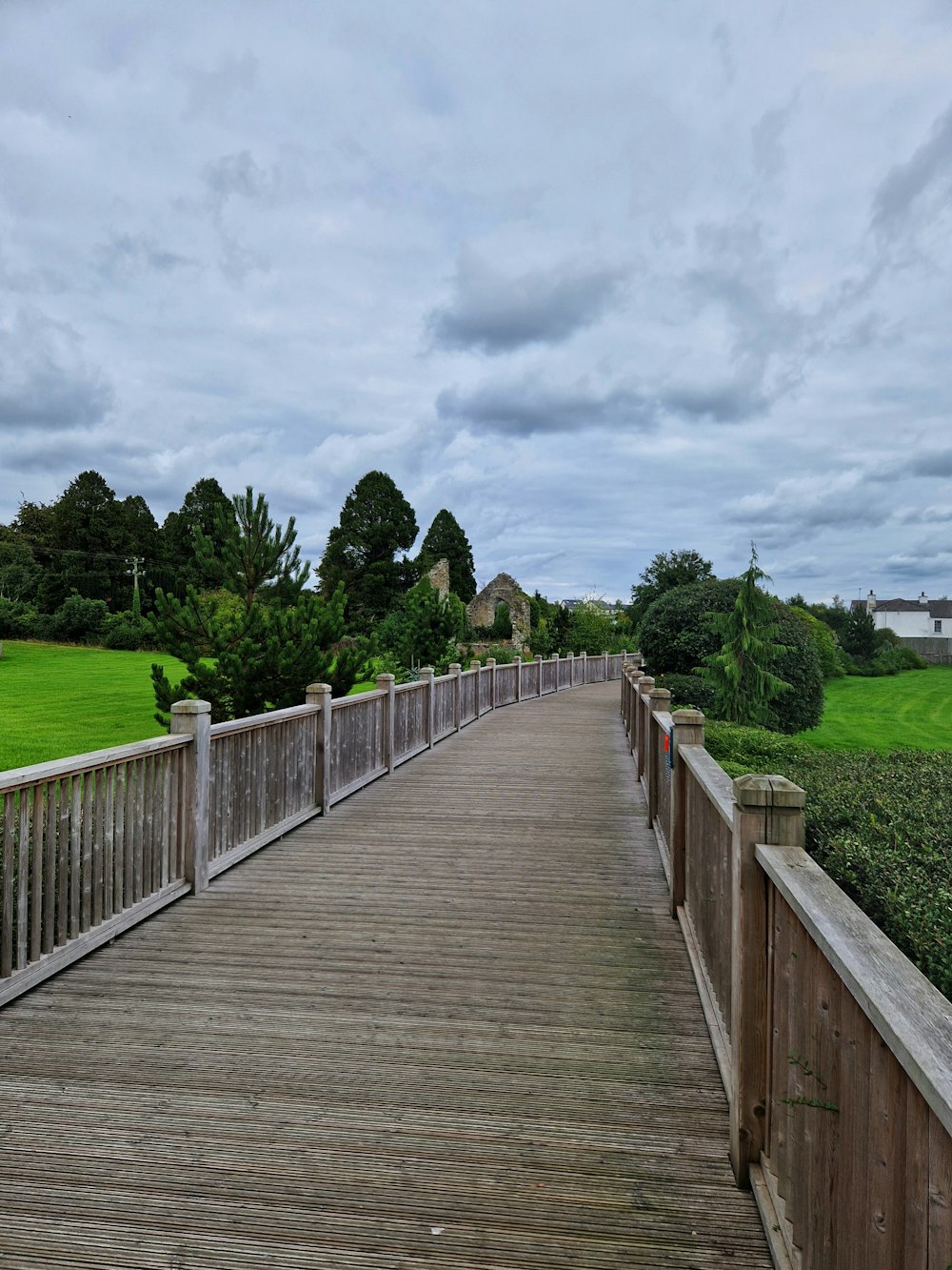 a wooden bridge over a grassy field