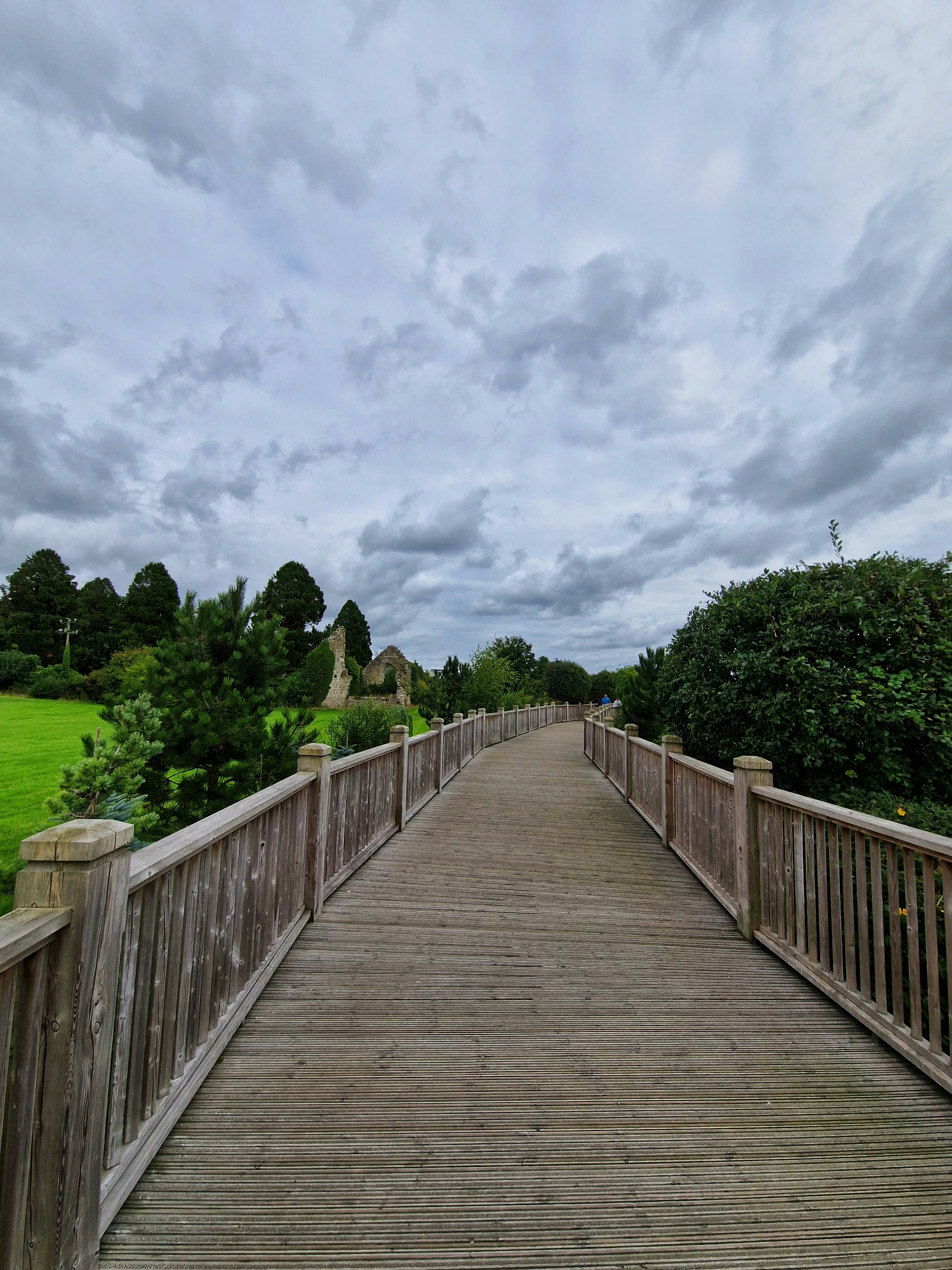 a wooden bridge over a grassy field