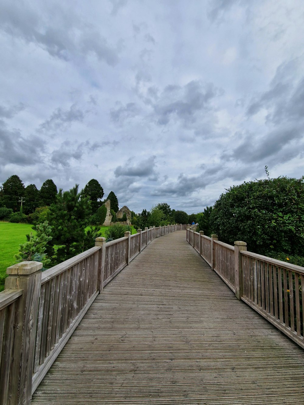 a wooden bridge over a grassy field