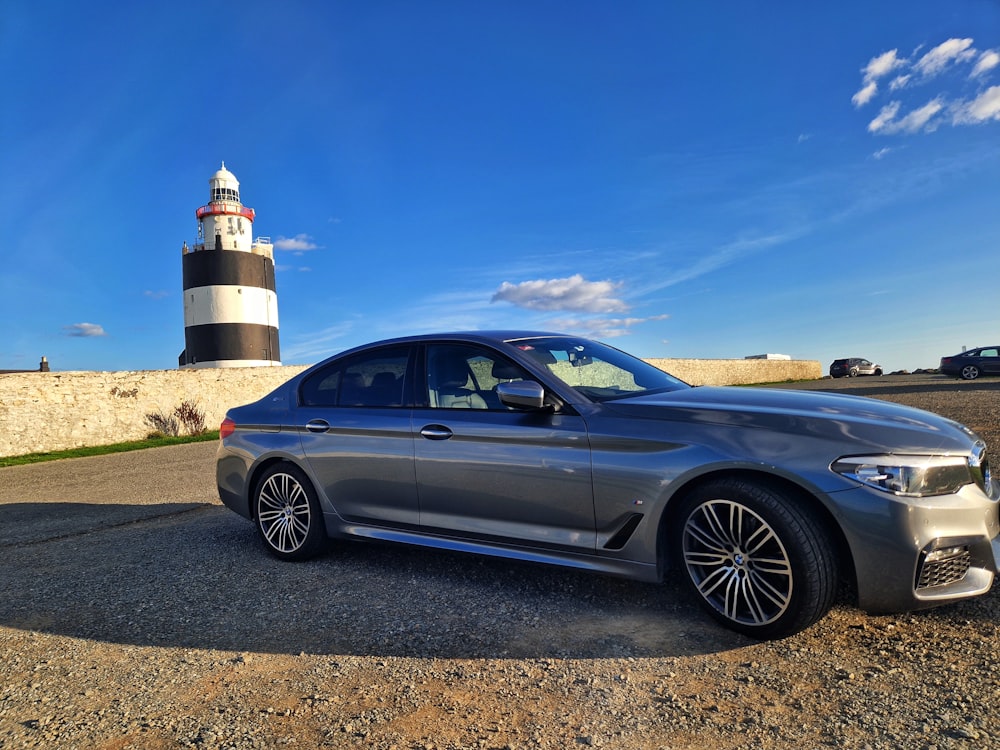a car parked in front of a lighthouse