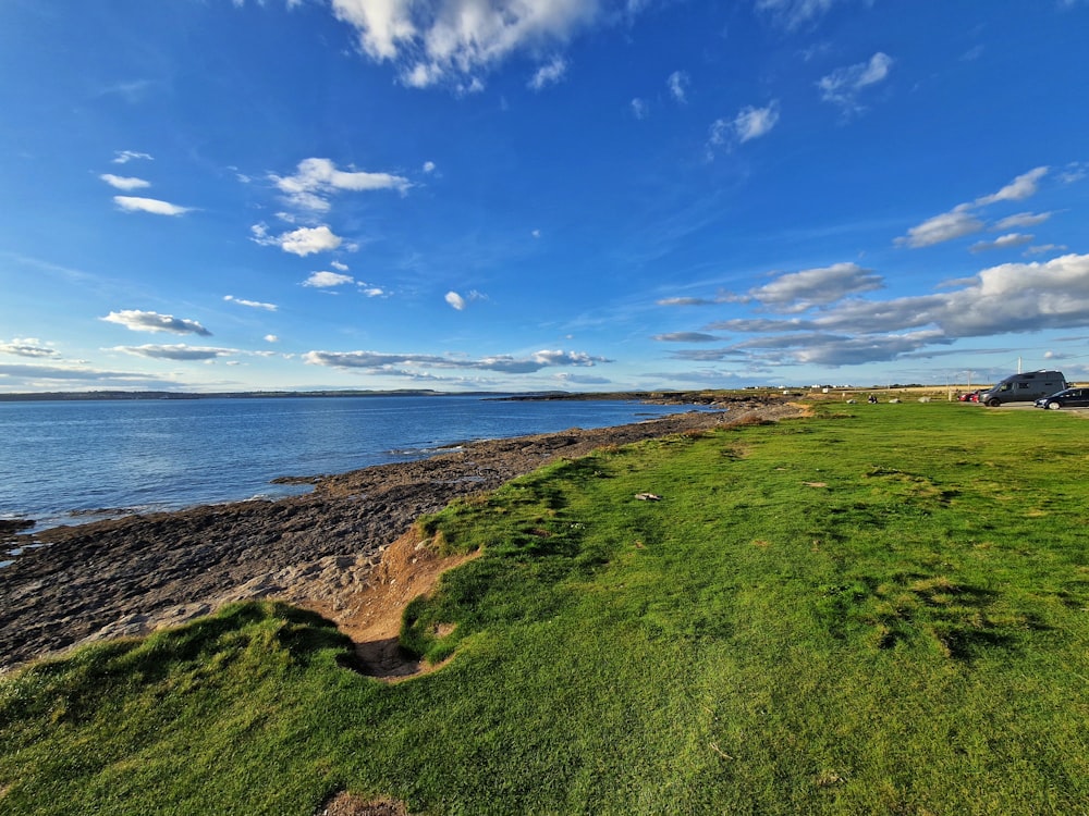 a grassy area next to a body of water