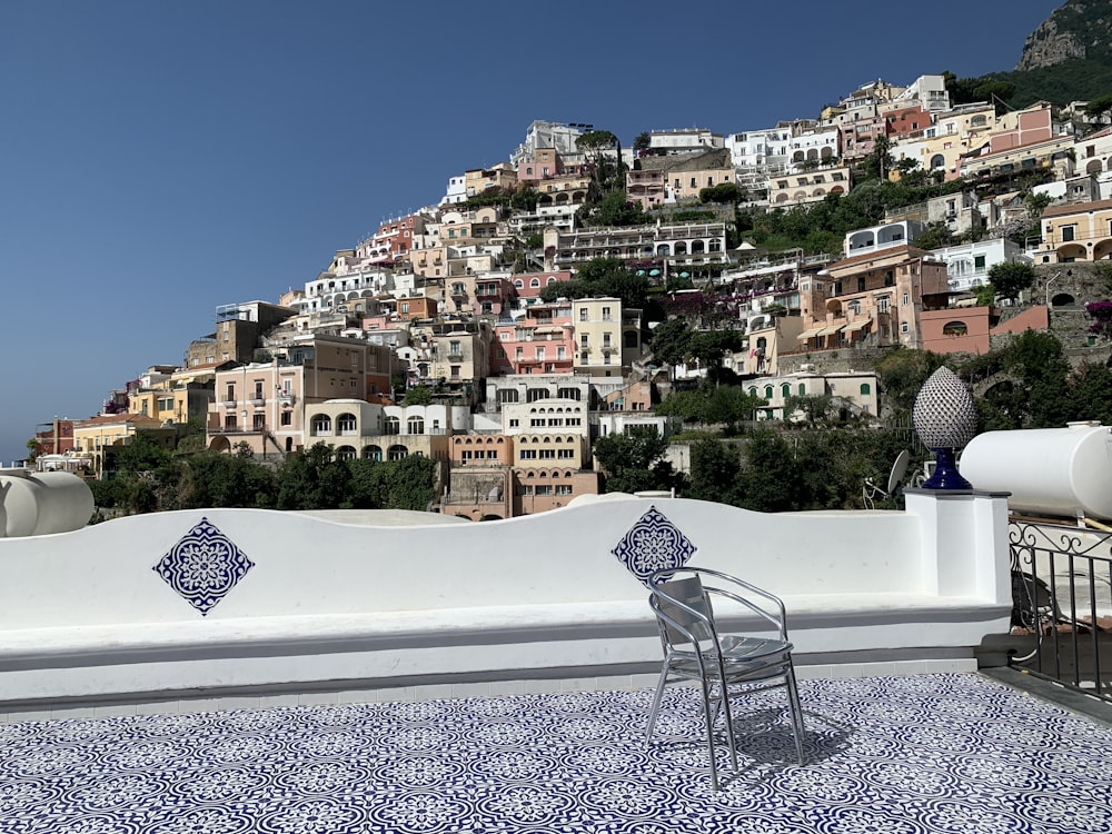 a white wall with a chair and a city in the background