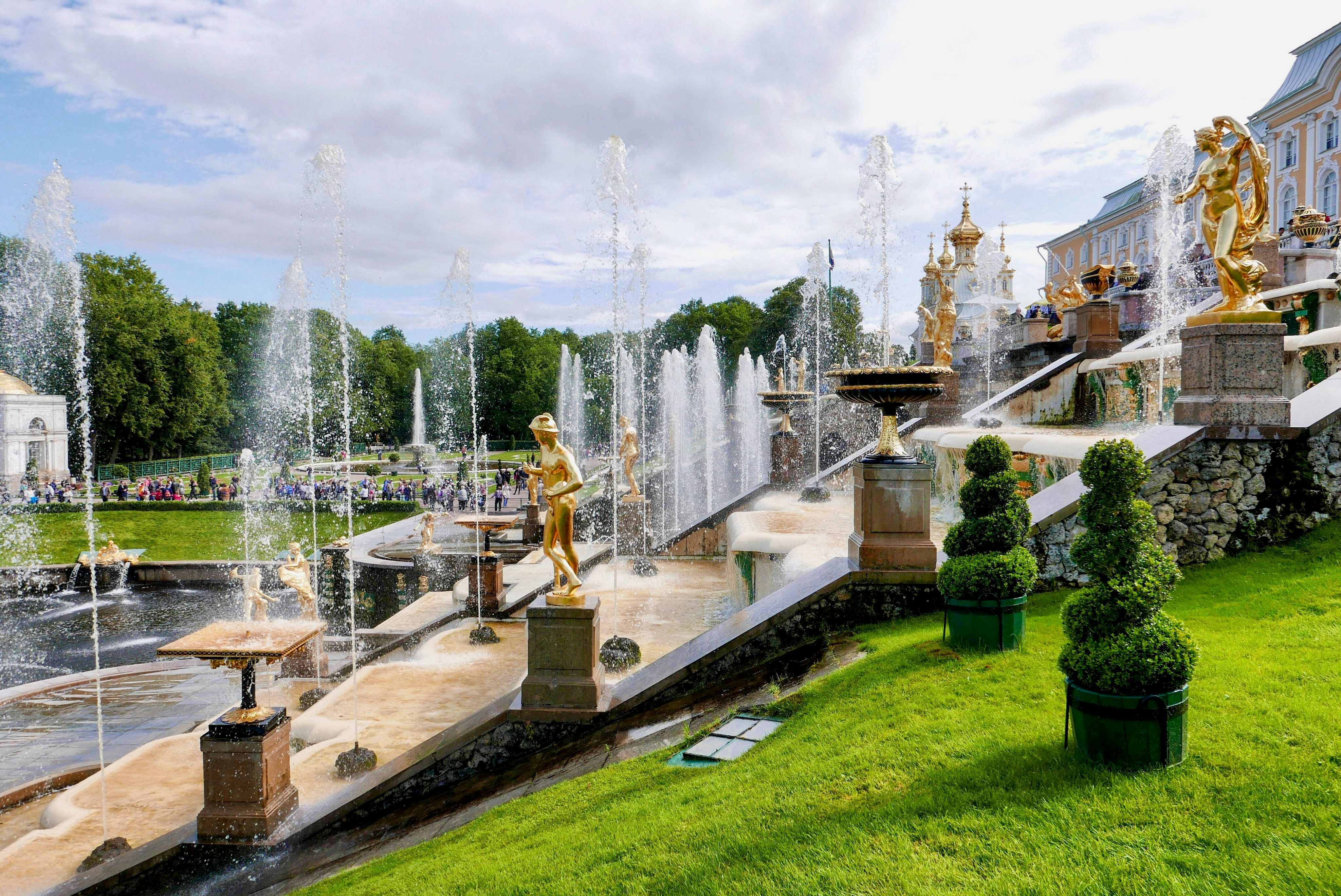 a fountain with statues and a building in the background