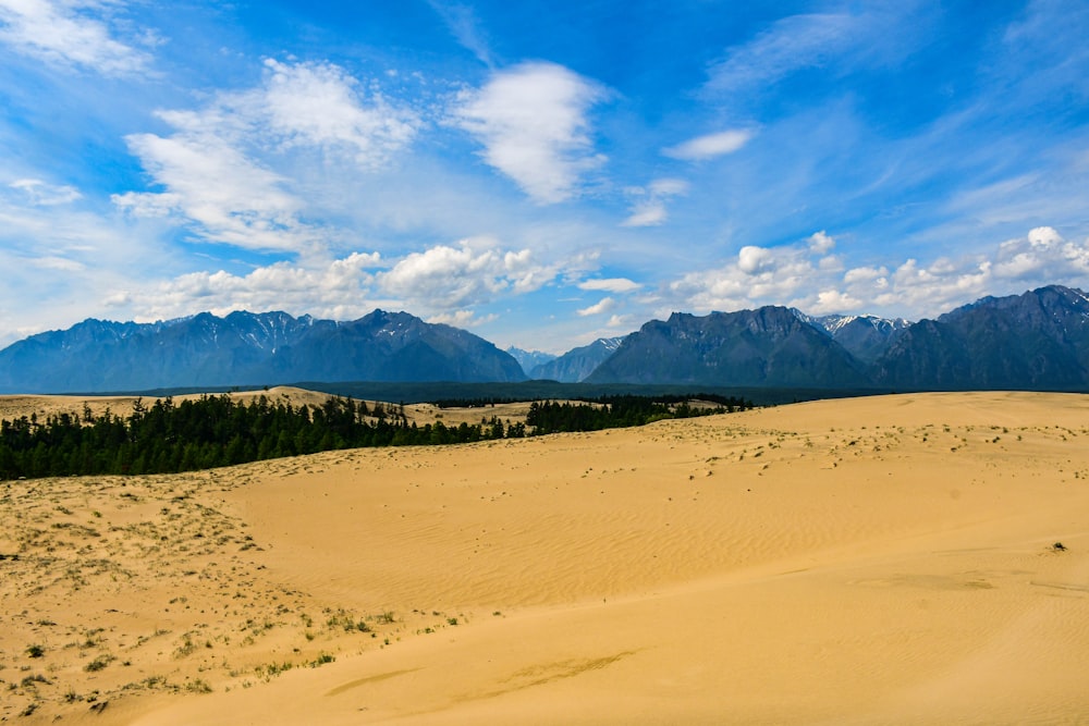 a sandy area with mountains in the background