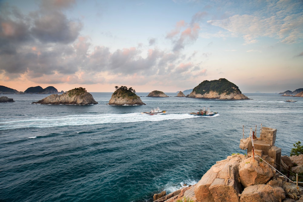 a rocky beach with a boat in the water