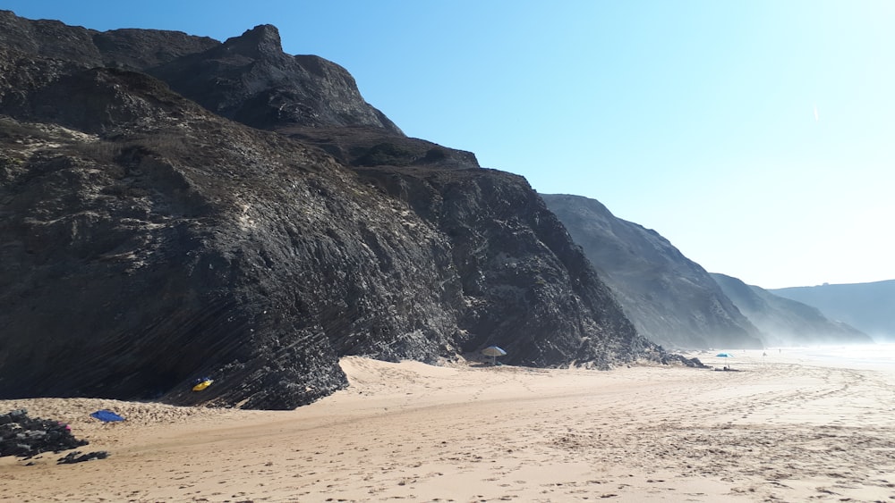 a sandy beach with a mountain in the background