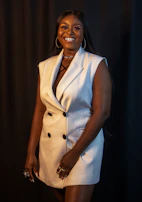 A joyful woman styling a versatile piece from day to night with simple accessories.