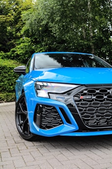 a blue car parked on a brick road