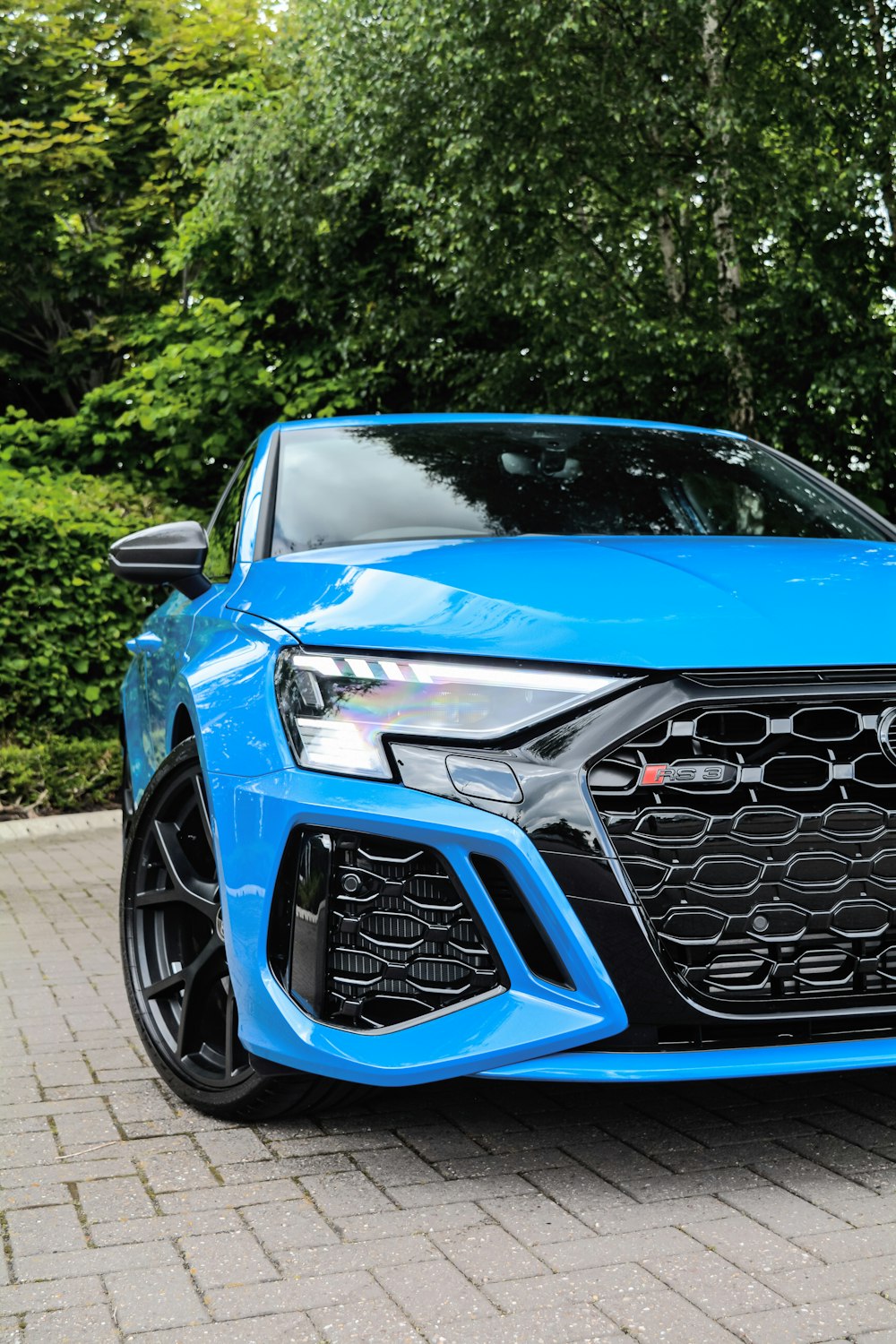 a blue car parked on a brick road