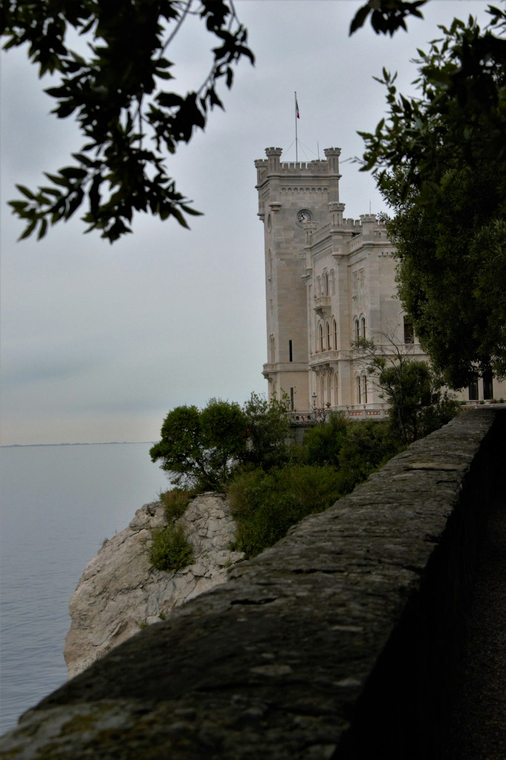 a stone building on a cliff by the water