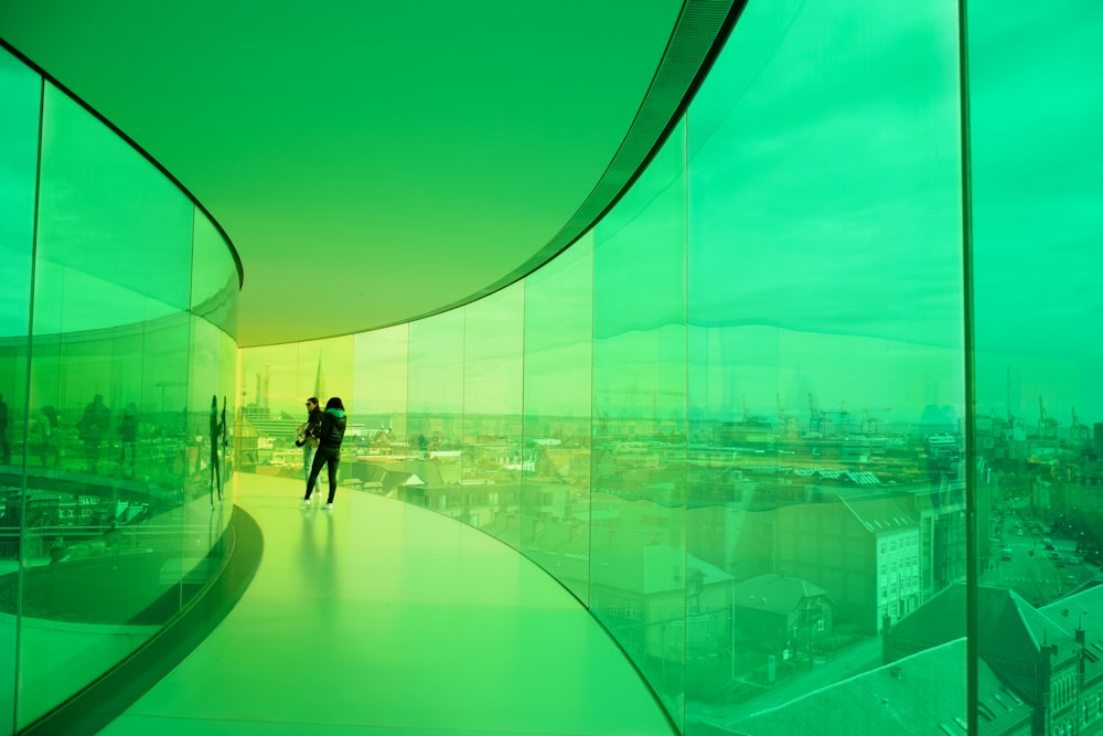 a man and woman walking through a glass walled room