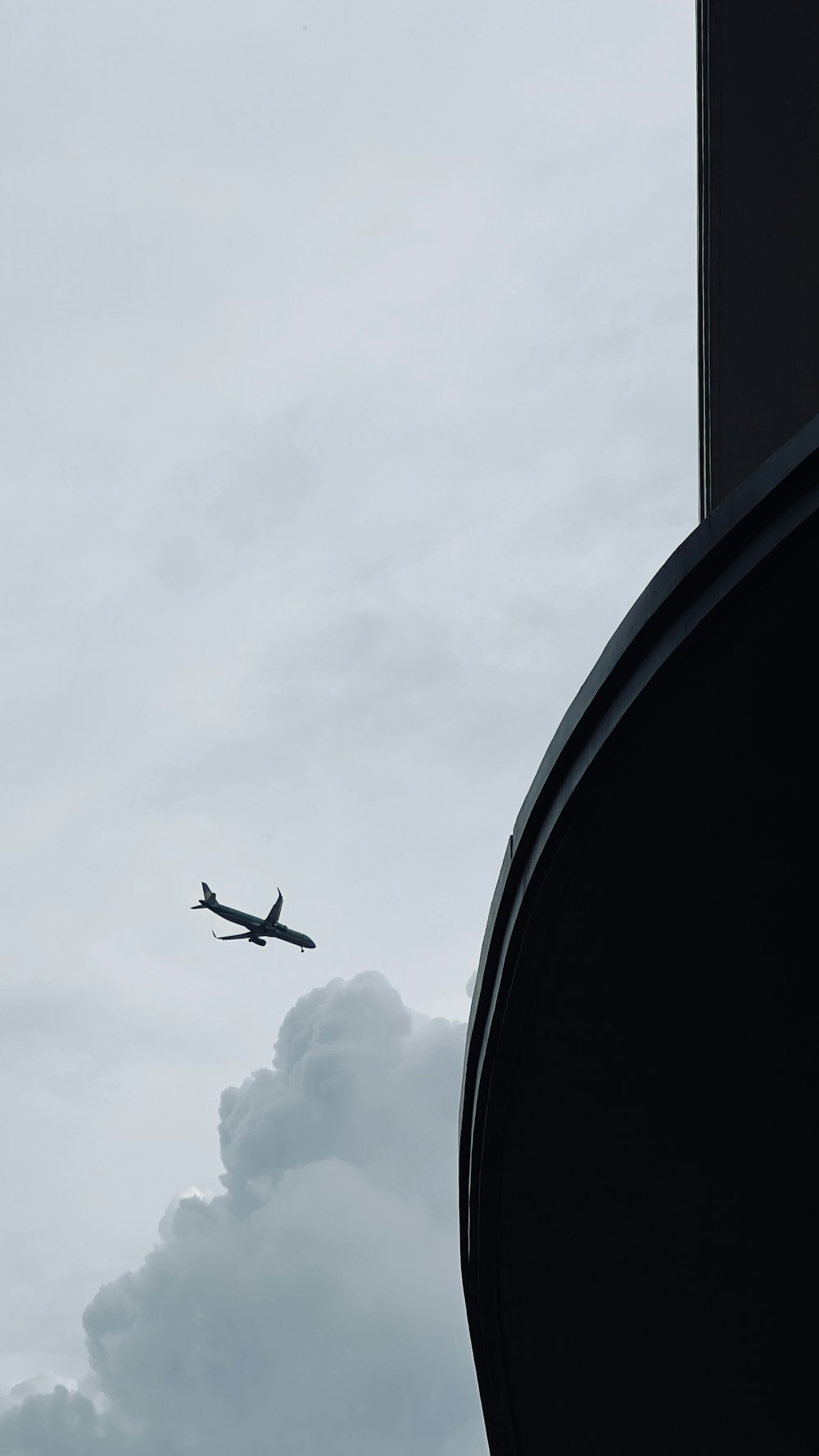 a large jet flying through a cloudy sky