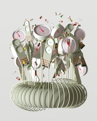 A collection of devices resembling clocks or gauges with colored indicators is attached to long, thin rods emerging from a coil structure. The devices have dials with red needles and various numerical scales. Surrounding the devices are individual pills and capsules floating through the air, giving a sense of motion.