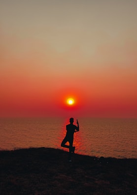 A peaceful yoga pose atop a cliff overlooking the turquoise sea.