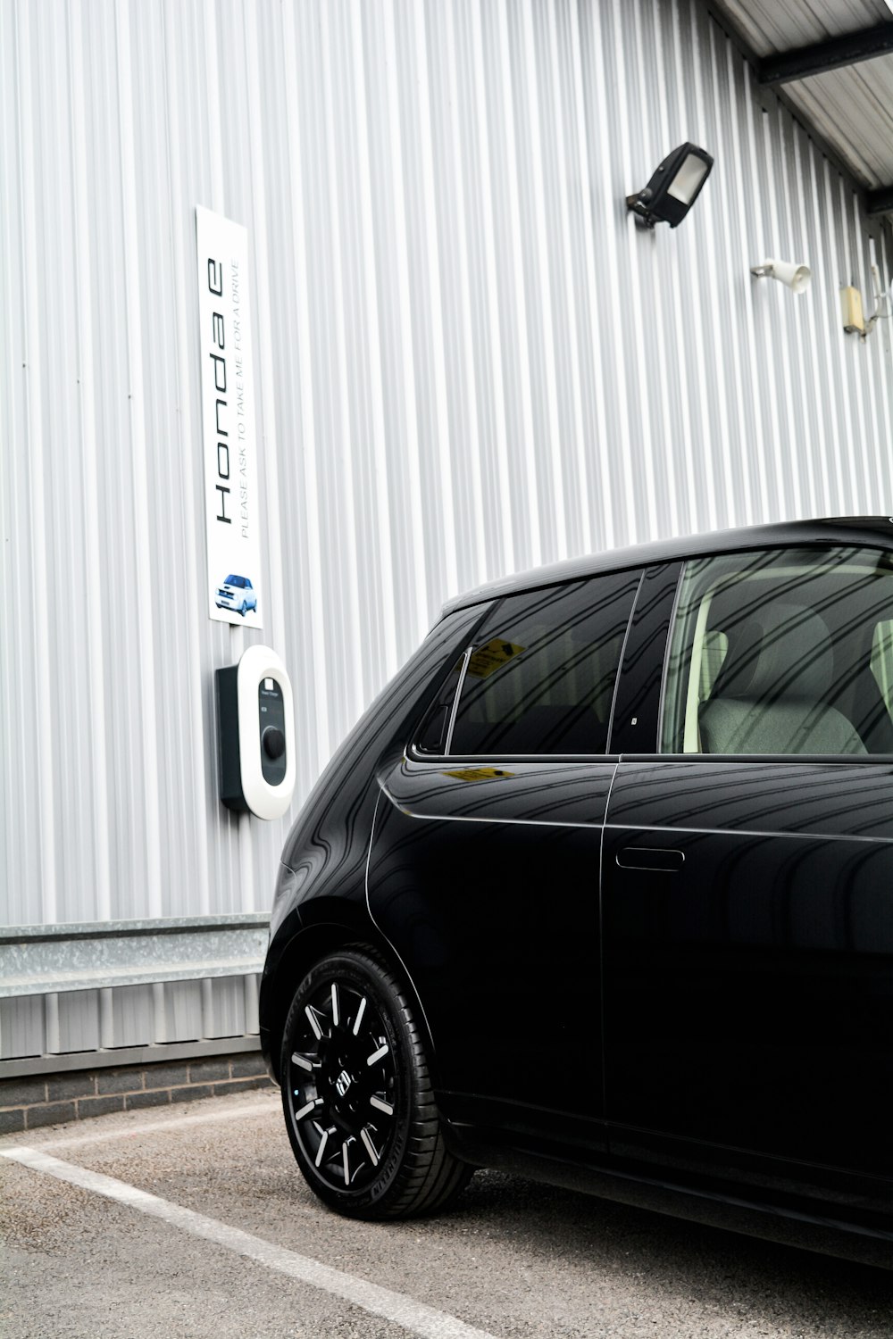 a black car parked in front of a white building