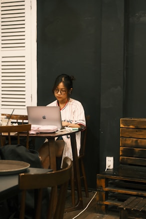 a person sitting at a table with a laptop