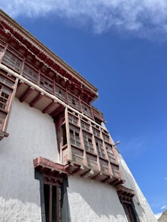Restoration work on a traditional building facade with workers carefully applying plaster details.