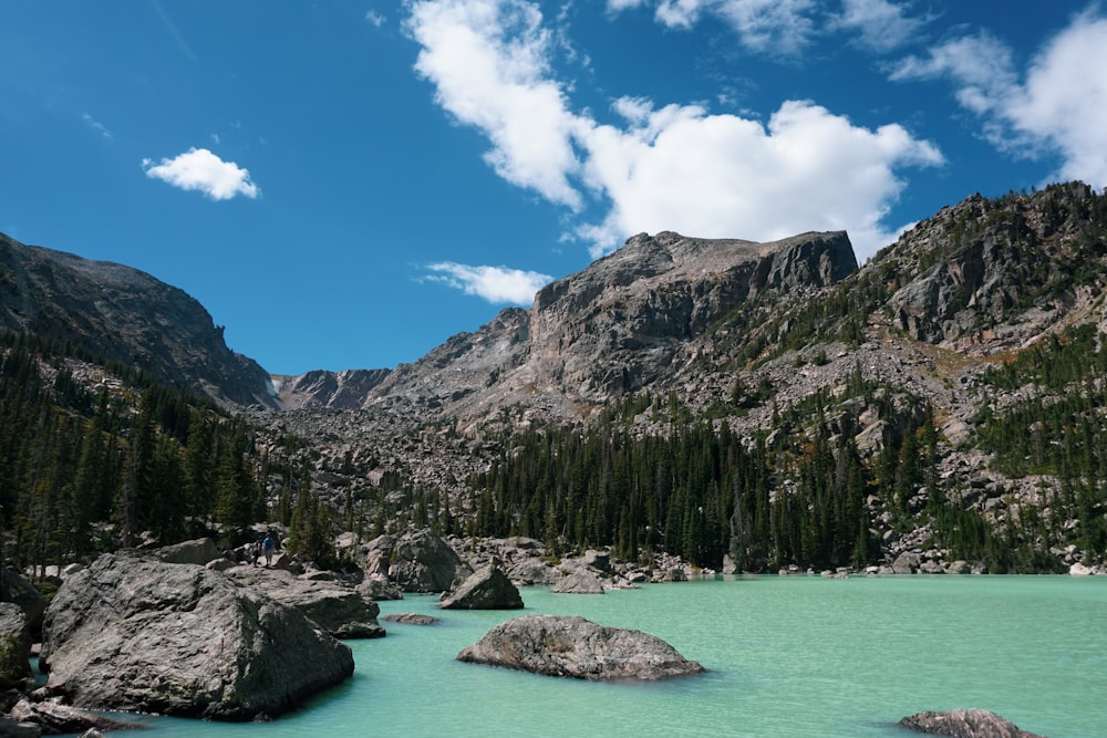 a body of water with trees and mountains around it