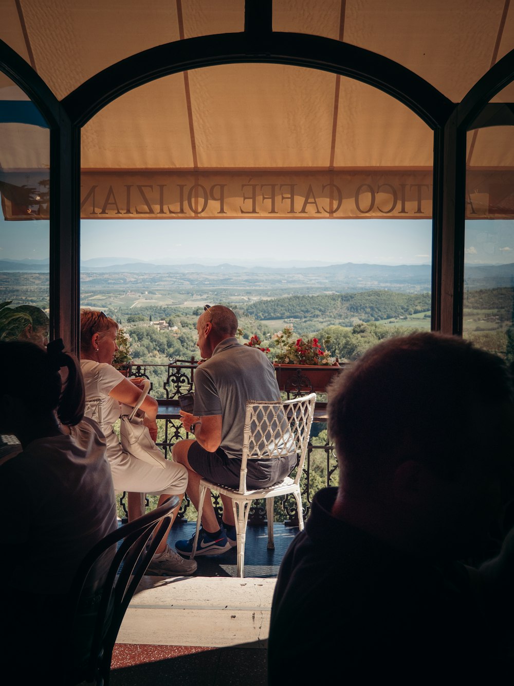 a group of people sitting at a table overlooking a city