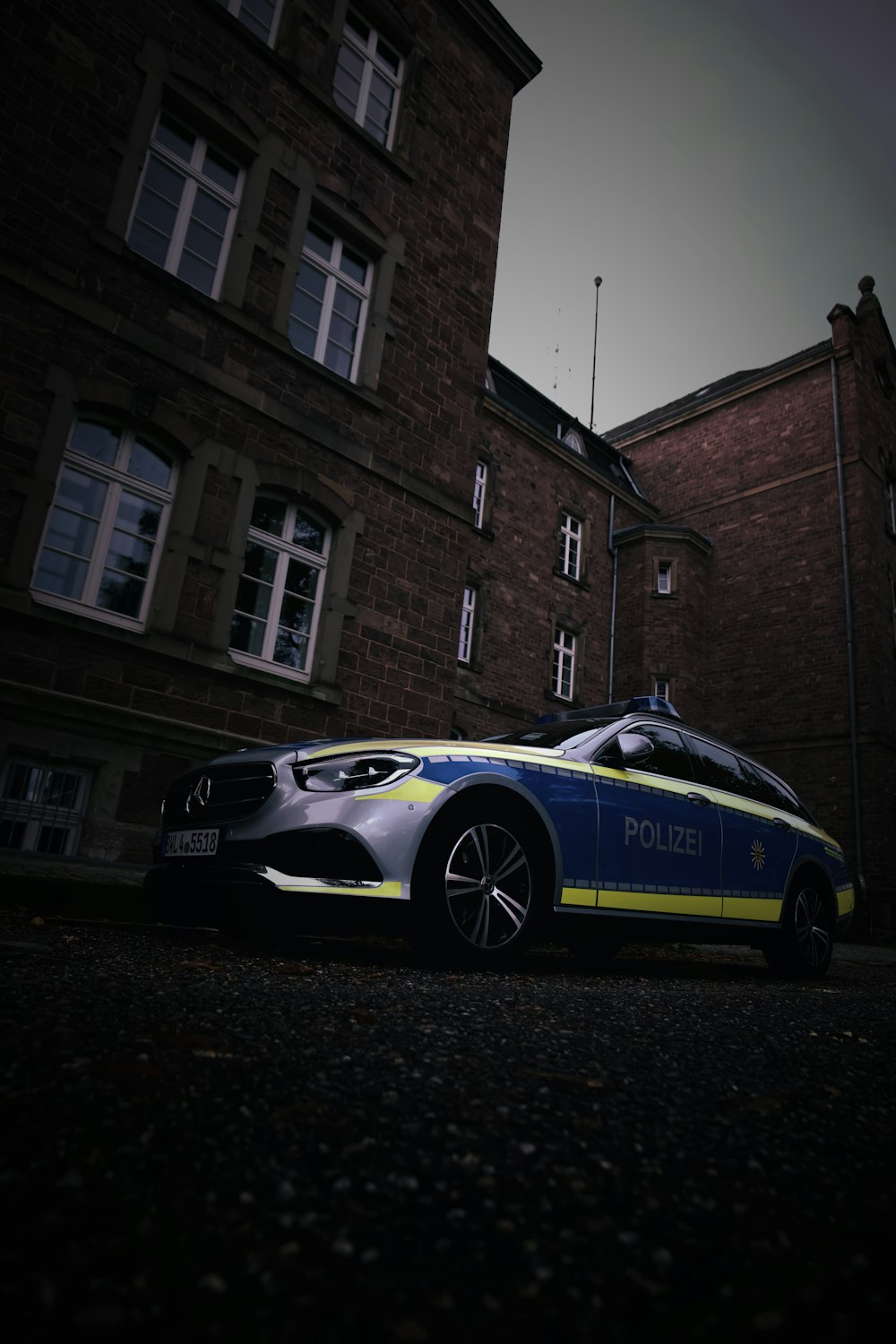 a sports car parked in front of a brick building