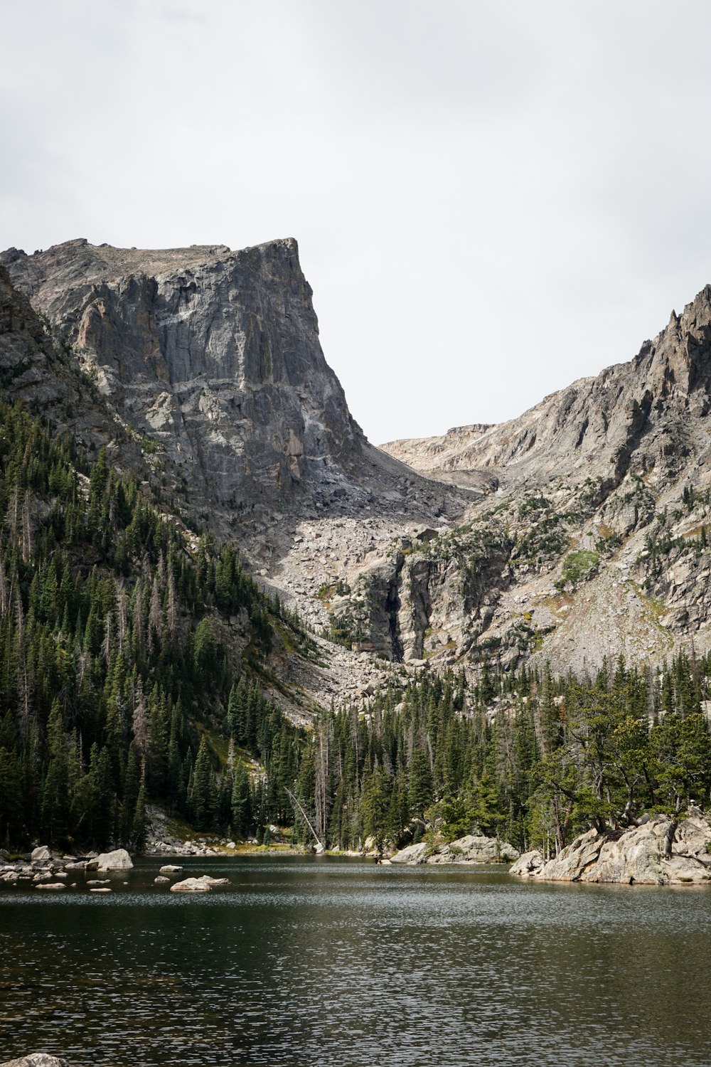 a lake with trees and mountains in the background