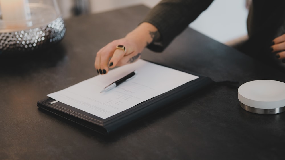 a person writing on a piece of paper