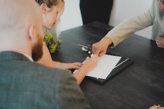 a woman showing a man something on a tablet