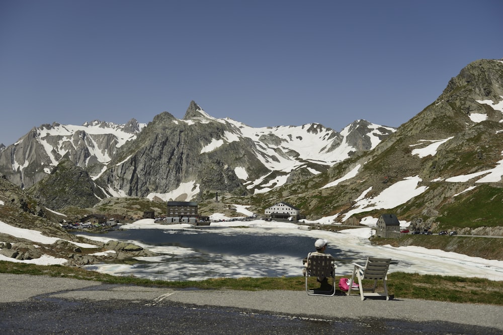 a man sitting on a bench in front of a mountain