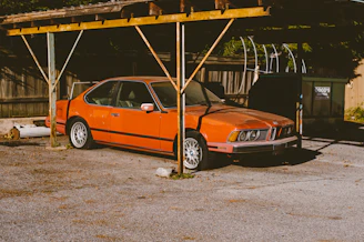 an orange car parked under a covered area