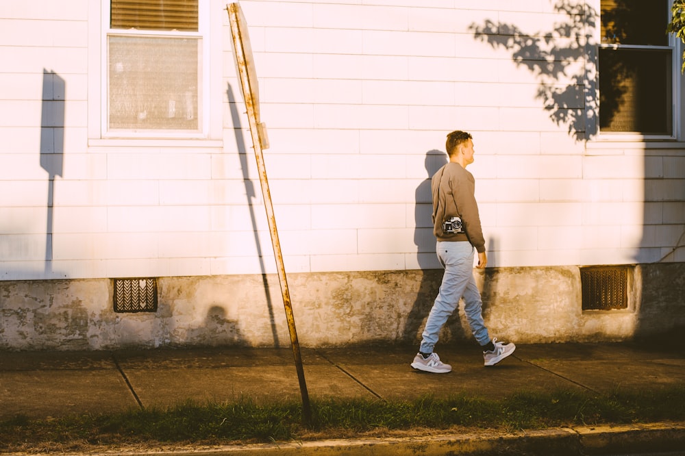 Un hombre caminando con una escoba