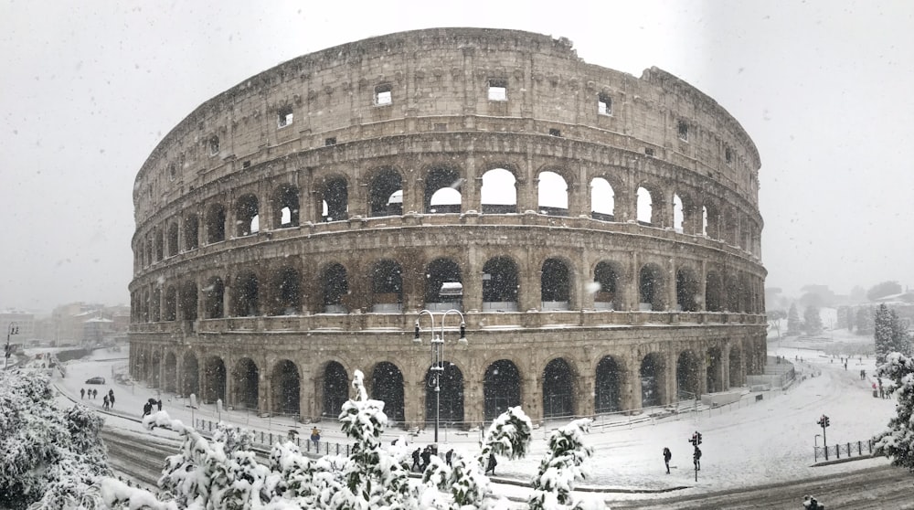 a large stone building with Colosseum in the background