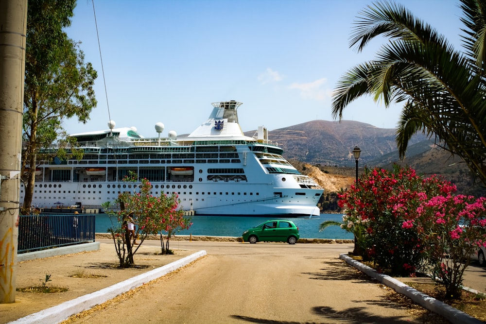 a car parked next to a large cruise ship