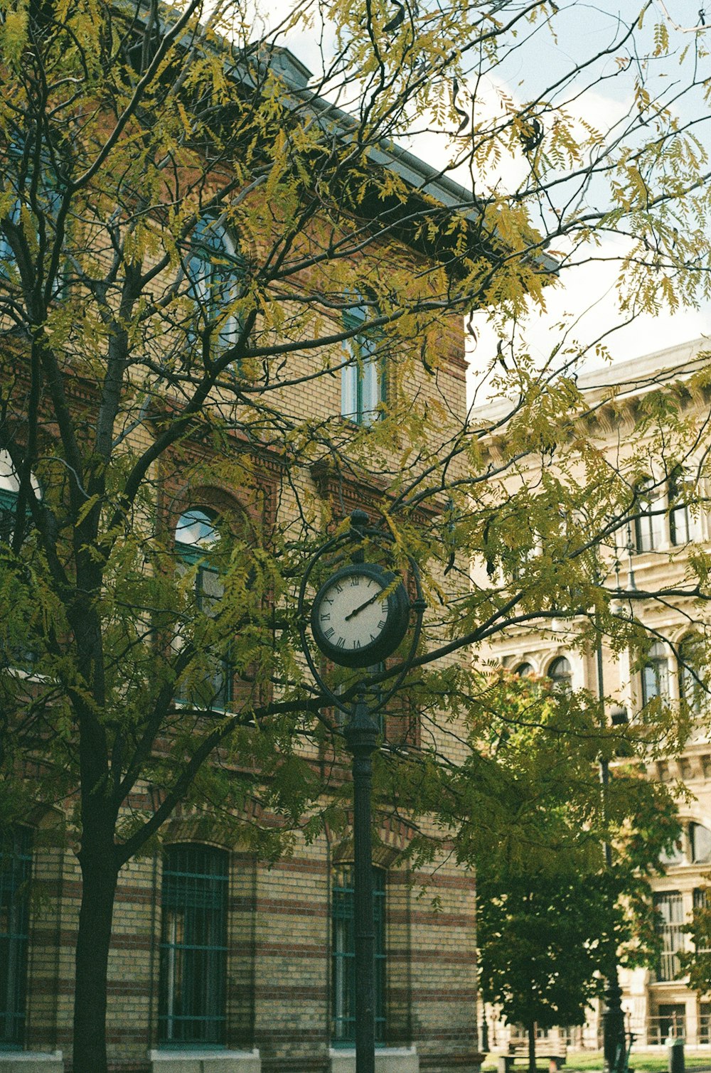 eine Uhr an einem Mast vor einem Gebäude