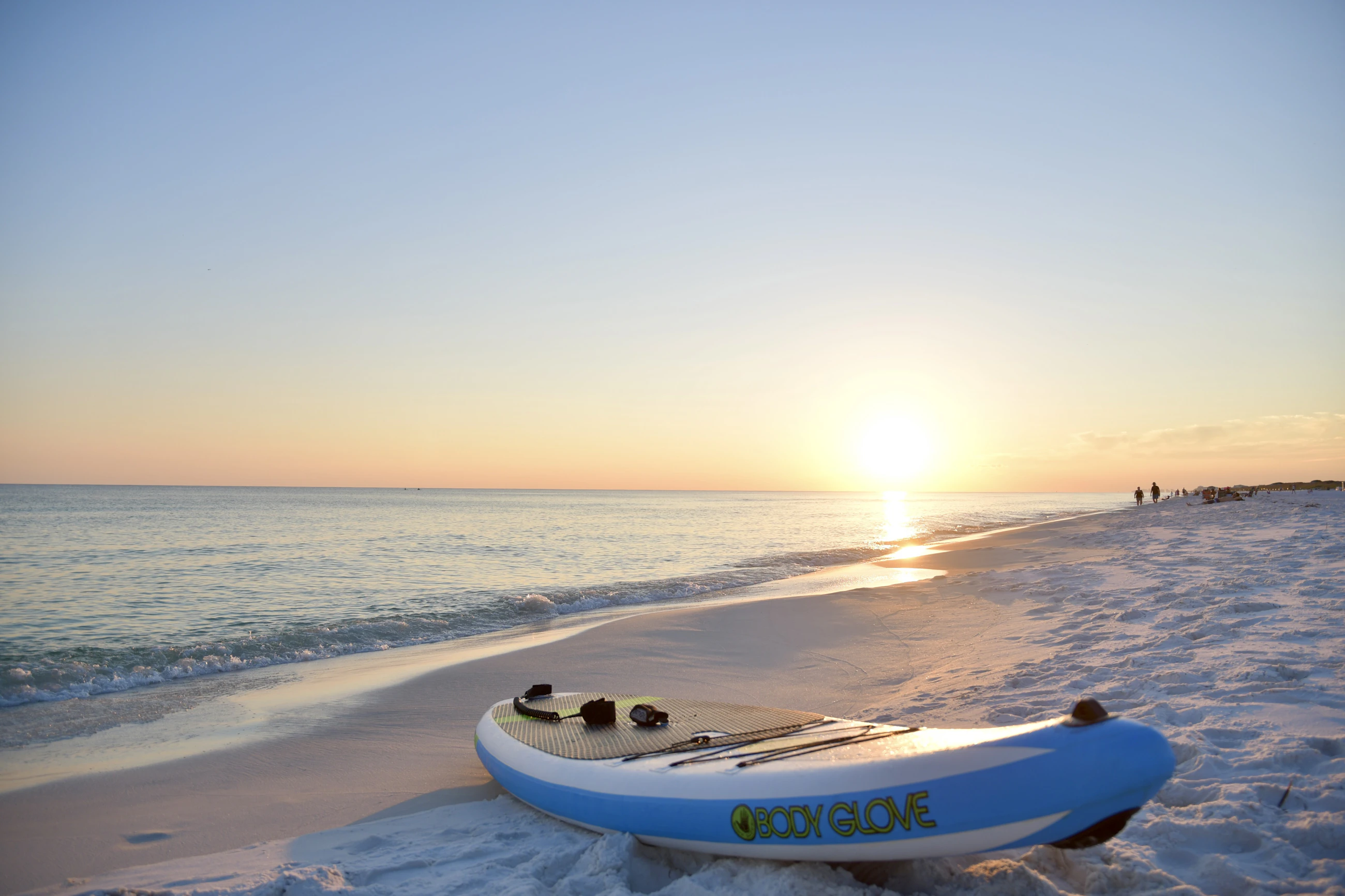 Paddleboard and coastal watercraft positioned on a sandy beach
