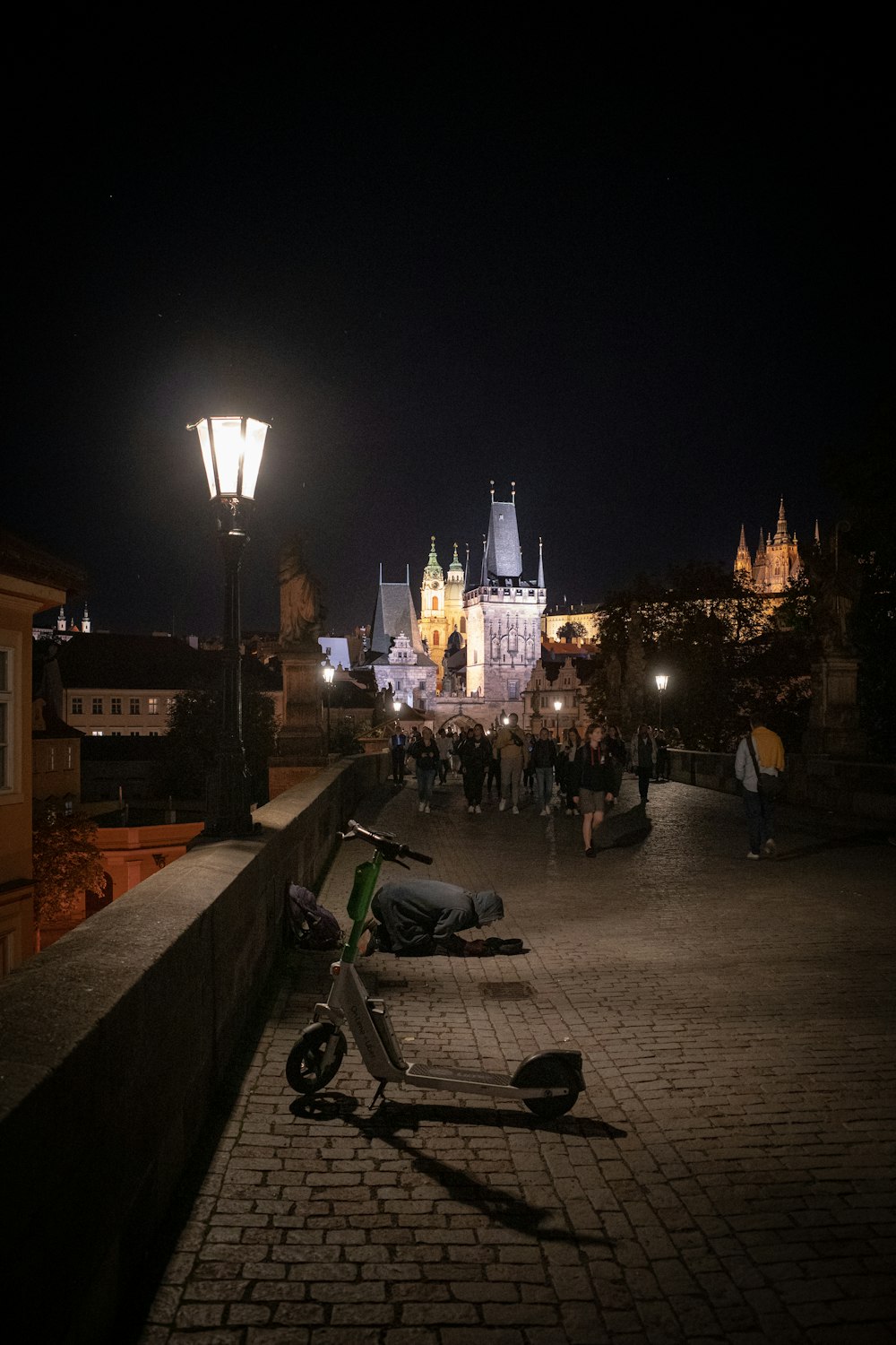 a group of people walking on a stone path with a city in the background