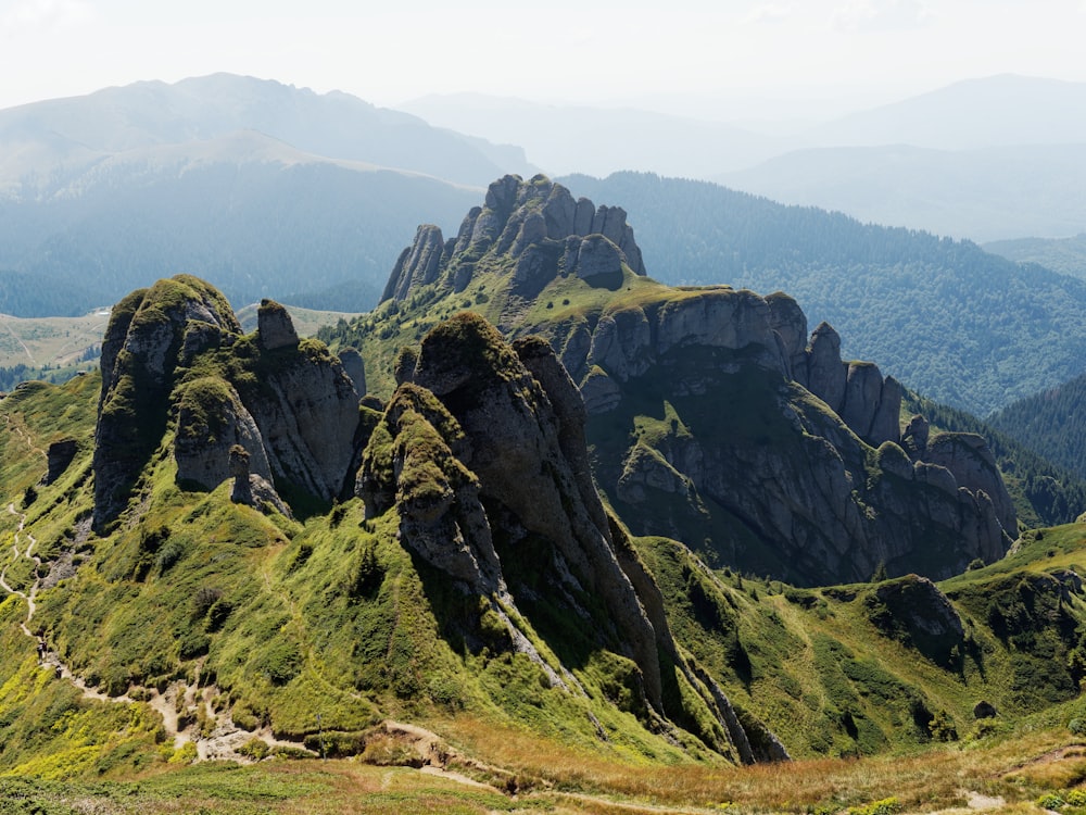 a rocky mountain with green grass