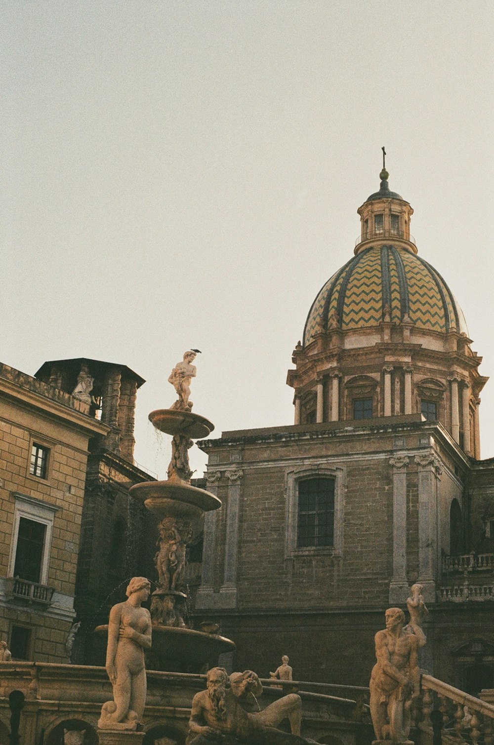 a fountain with statues in front of a building