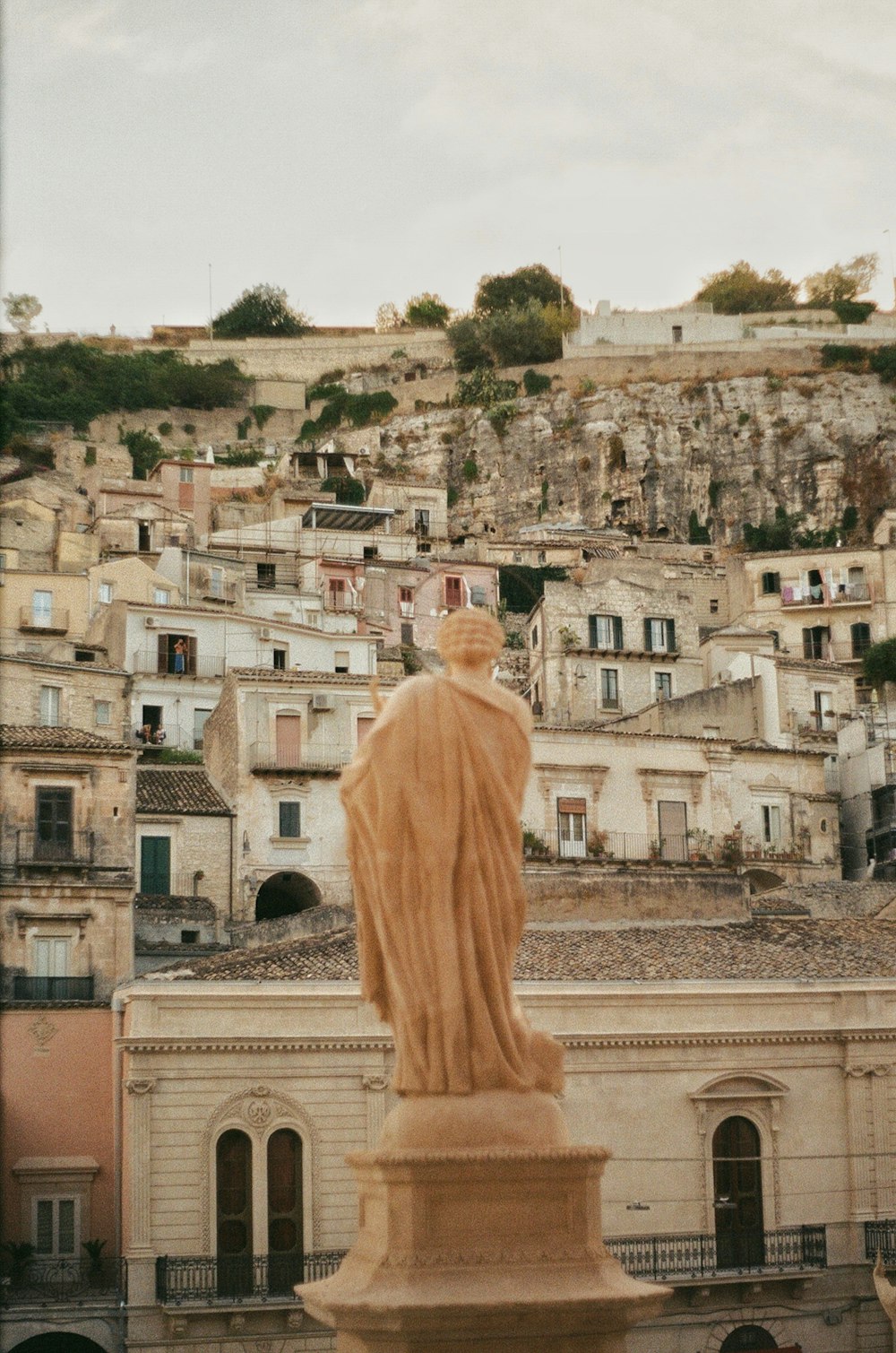 a statue of a person in front of a city