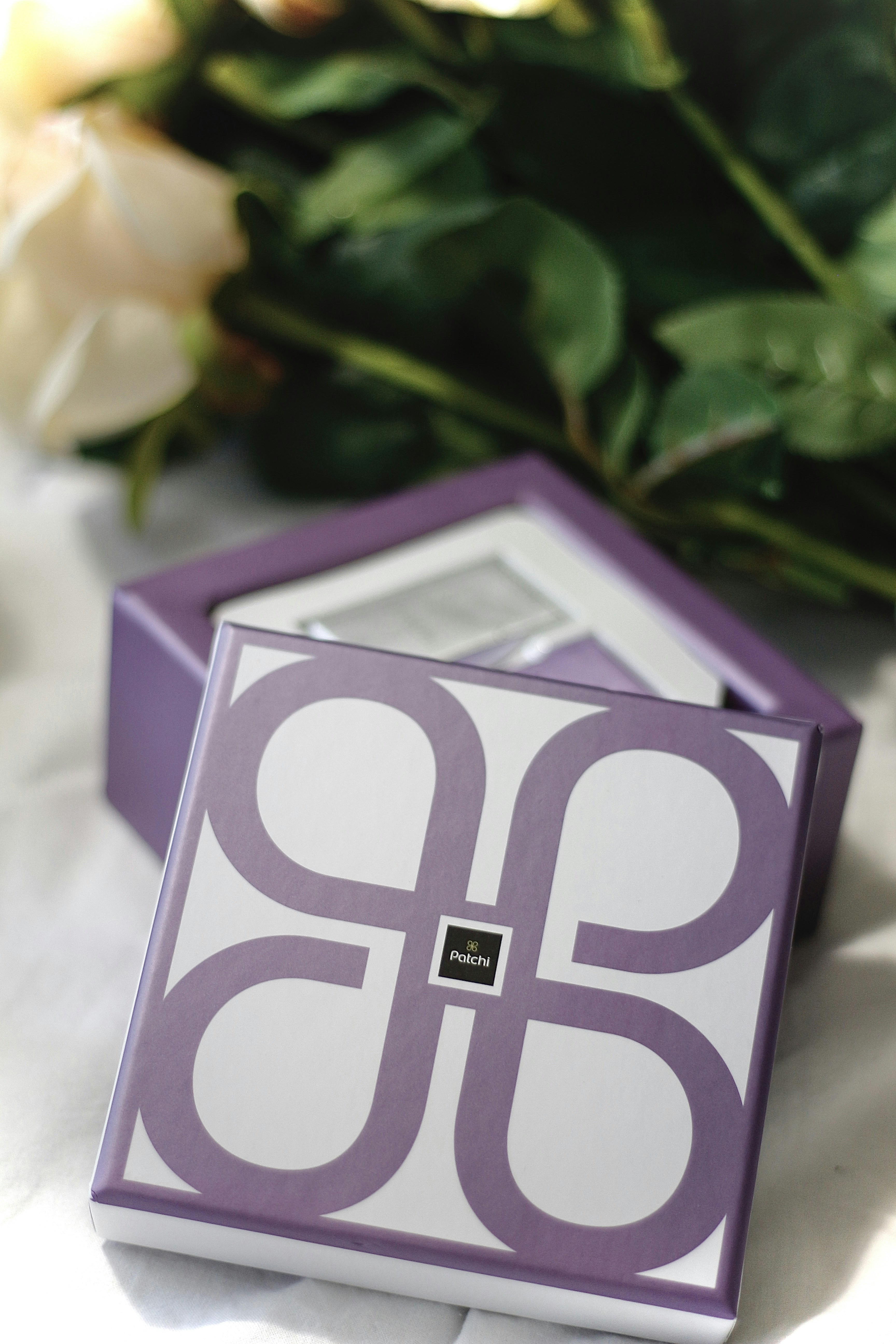 a purple and white container with a flower in the background