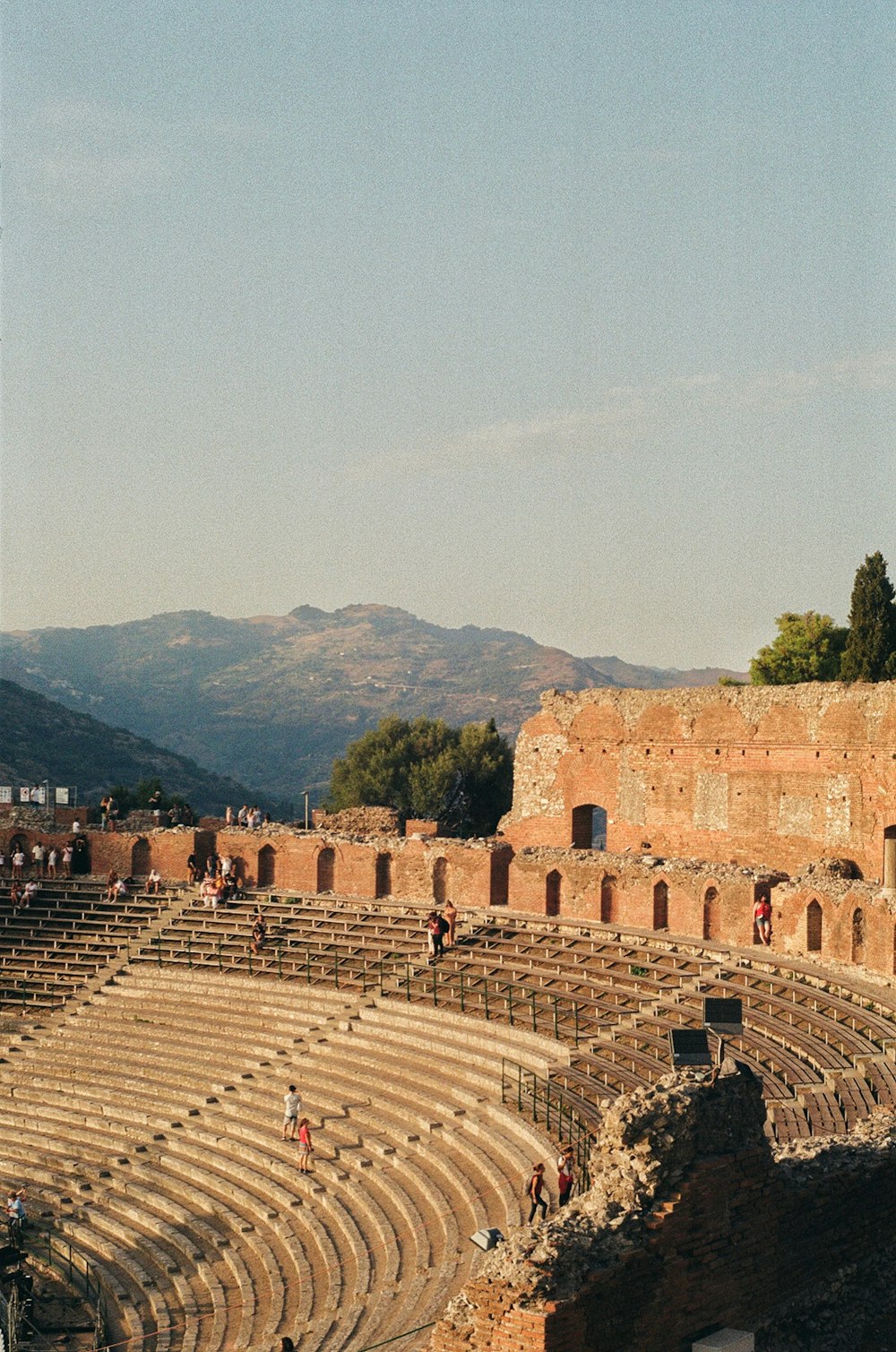 a large ancient building with people standing on the stairs