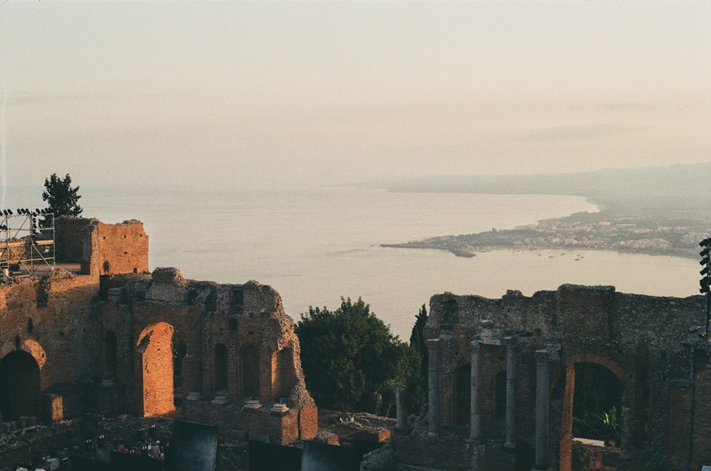 un grande edificio in pietra con uno specchio d'acqua sullo sfondo