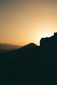 A serene outdoor scene with a filmmaker capturing a sunset over rolling hills.