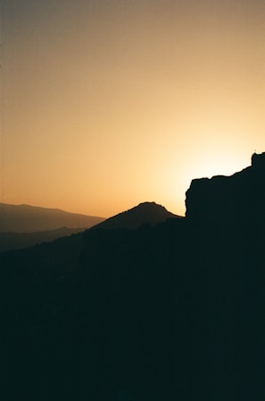 A serene landscape photograph showcasing rolling hills at sunset.