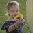 a young girl holding a yellow flower