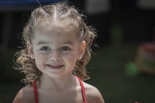 a little girl with a red strap