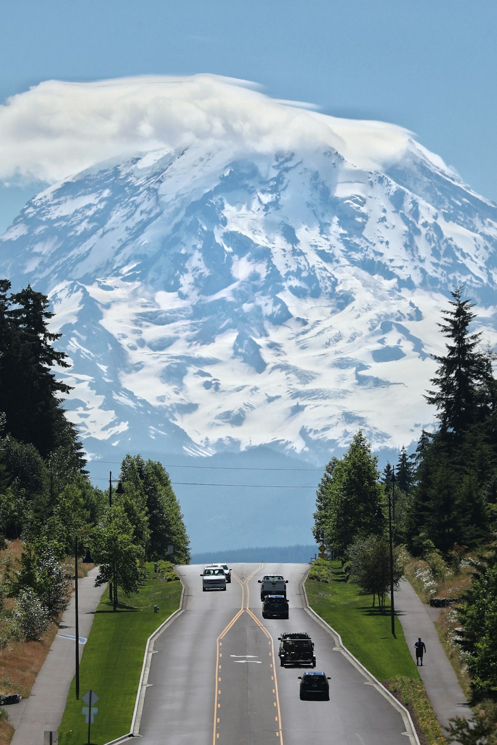 a road with cars on it and a mountain in the background