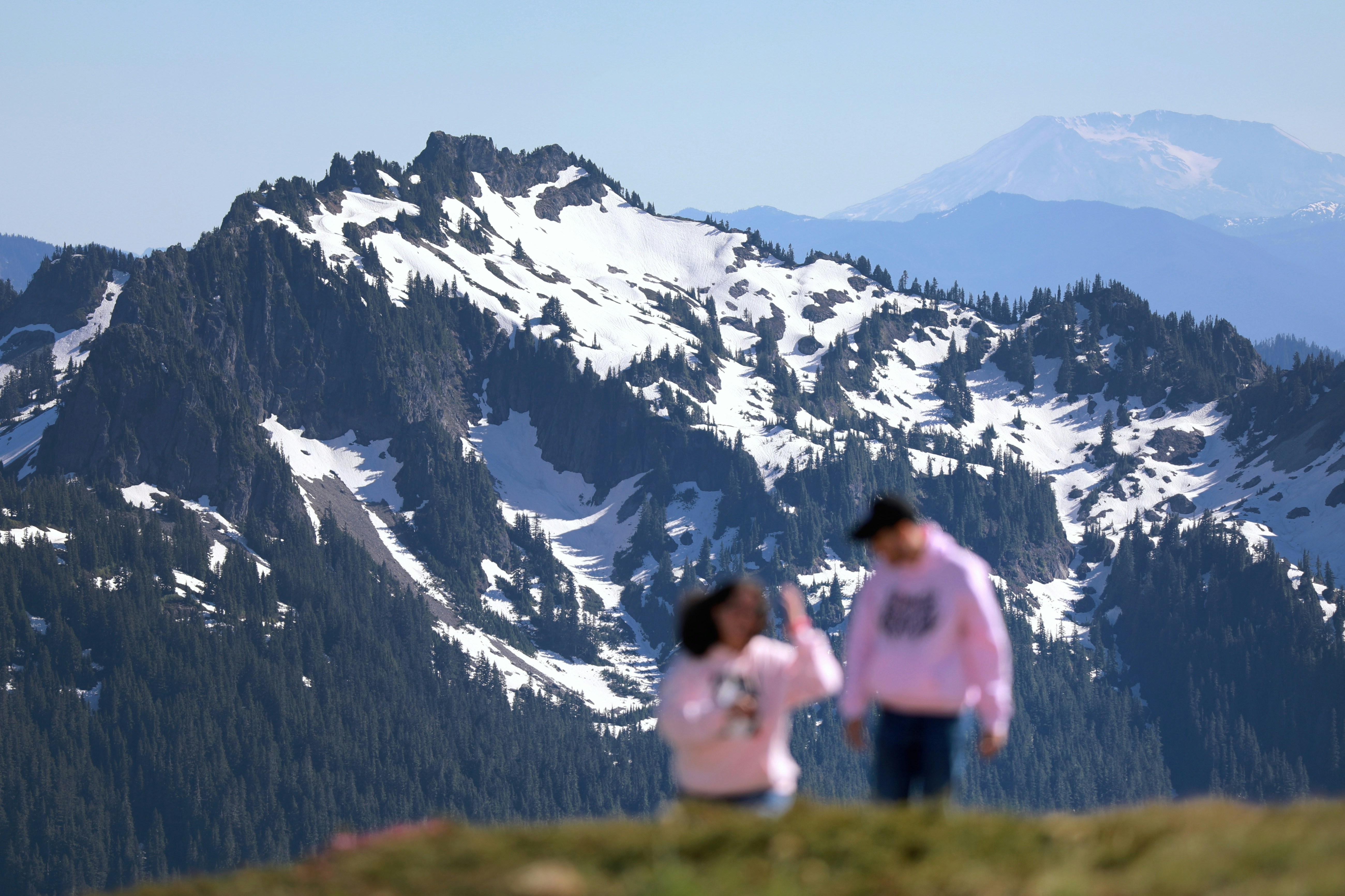 couple hiking with a stunning mountain backdrop - vacation ideas for new couples